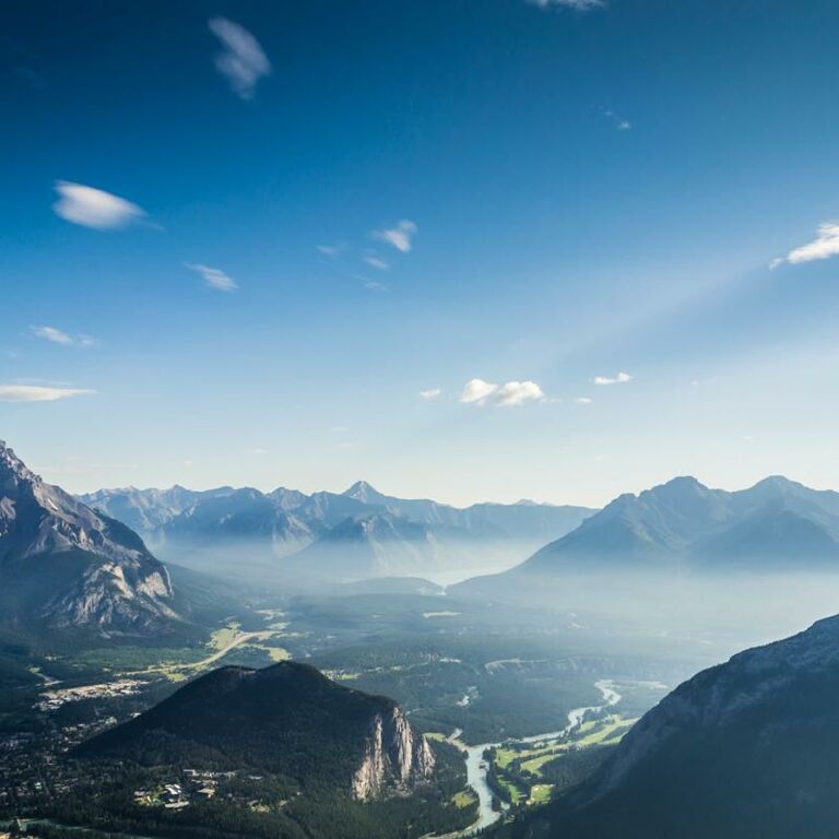 Ein bläuliches Bergpanorama mit einem großen Tal und einem Fluss